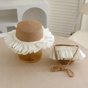 Detail of straw hat and matching crossbody bag set with elegant white ribbon ruffles