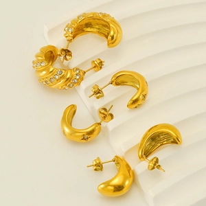 Golden C-shaped earrings with spiral textures and star-engraved rhinestone details