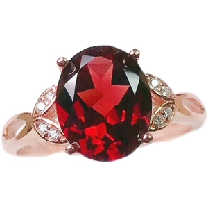 Minimalist oval red garnet ring in rose gold with leaf-shaped diamond accents on white background