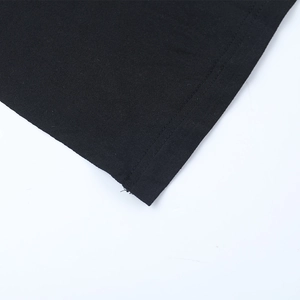 Gros plan détaillé de l'ourlet à double couture sur une robe noire en maille