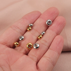 Macro shot of gold and silver stainless steel beads for jewelry making on palm