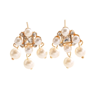 Detailed macro of vintage pearl tassel earrings with gold plating and square crystals