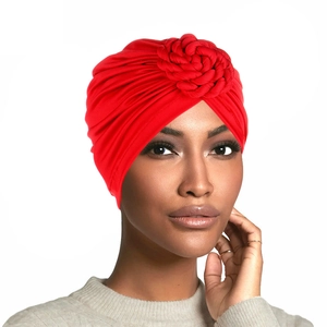 Gros plan détaillé du turban rouge avec un motif décoratif de fleur en spirale