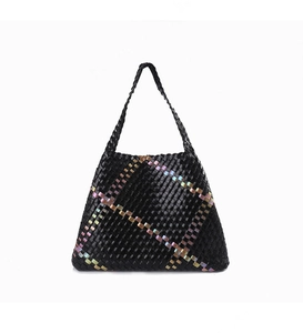 Detail of hand-woven black tote bag featuring colorful rainbow plaid accents and shoulder strap