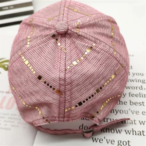 Detail of pink baseball cap featuring gold sequins, square studs, and adjustable strap