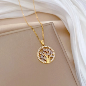 Golden Tree of Life necklace with cubic zirconia on beige fabric and white silk