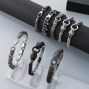 Detail of snake scale textured punk bracelets in silver and matte black finishes