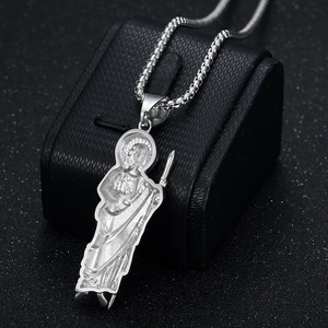 Polished silver St. Jude pendant necklace with detailed relief on a black display stand