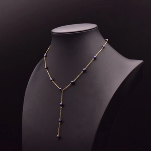 Elegant gold Y-shaped necklace with black freshwater pearls on a black display stand