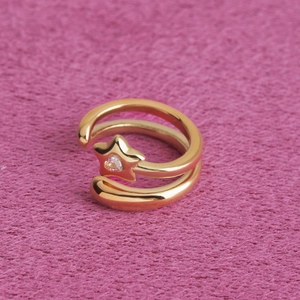 Gros plan d'une bague étoile dorée avec pierre précieuse en forme de cœur