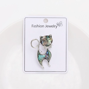 Detail of cat brooch with natural abalone shell inlay and sparkling bow tie detail