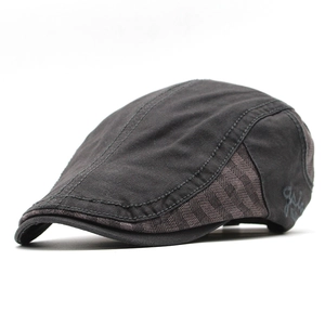 Detail of dark grey cotton beret featuring side plaid patchwork and embroidered letters