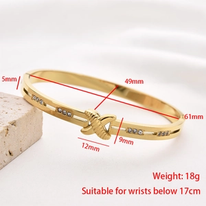 Close-up of stainless steel bangle with X-symbol and engraved dimension measurements