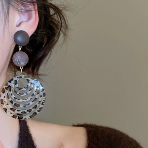 Macro view of vintage resin leopard print hoop earrings on model with autumn vibes