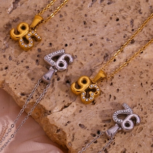 Top view of 18K gold and silver numbered pendants with crystal pavé on stone