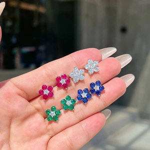 Macro shot of colorful zircon flower earrings in red, blue, green, and white silver studs