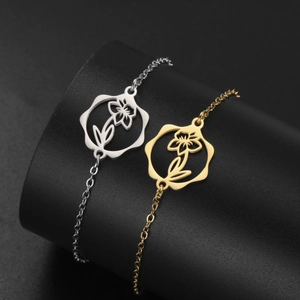 Macro view of gold and silver stainless steel bracelets with hollow floral pendants