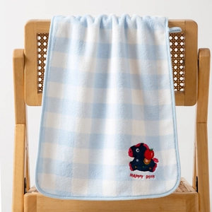 Detail of coral fleece bath towel with blue checkered pattern and pony embroidery