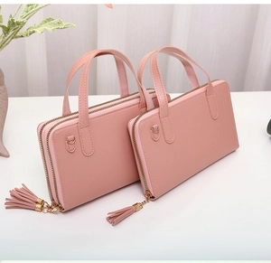 Detail of pink double-layer handbags with gold zippers, tassels and soft faux leather texture