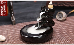 Detail of black ceramic backflow incense burner with multi-tier waterfall smoke effect