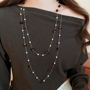 Gros plan d'un collier double rang avec œil de tigre brun et perles blanches