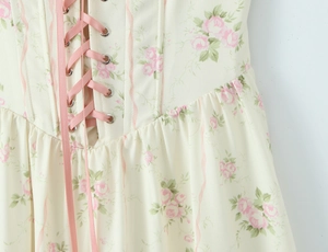 Dettaglio dell'abito floreale con stampa di rose rosa e allacciatura stile corsetto