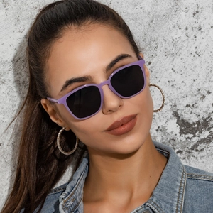 Close-up of trendy purple square sunglasses and large sparkling round crystal earrings