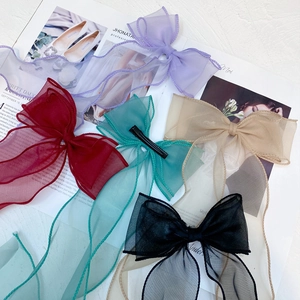 Detail of multi-color organza hair clips with shimmering bow design and metal alligator base