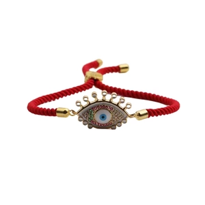 Adjustable red woven cord bracelet featuring a gold Evil Eye charm with colorful crystals