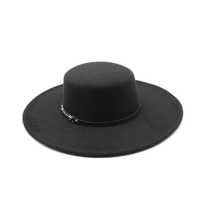 Detail view of a black wool boater hat featuring a thin faux leather band and gold buckle