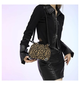 Detail of trendy leopard print bucket bag with silver metal corners on a female model