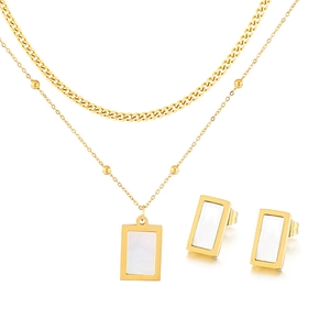 Detailed shot of golden layered necklace and earrings featuring white mother of pearl inlay
