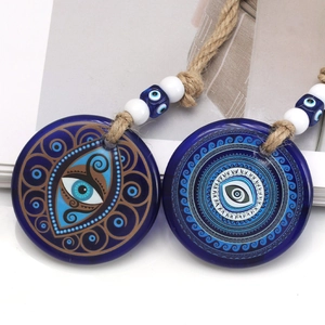 Detailed view of blue glass evil eye pendants with intricate swirl patterns and twine cords