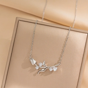 Elegant silver tulip pendant necklace with sparkling cubic zirconia on a champagne stand