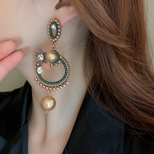Detail of vintage flower earrings with pearls and diamonds worn by a model