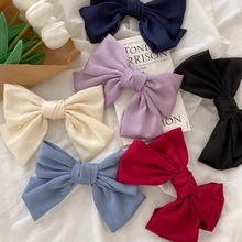 Chic knotted headbands and bow clips displayed with white tulips on a clean fabric backdrop