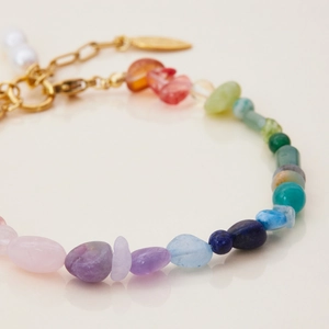 Detailed macro view of colorful natural gemstone beads and gold stainless steel star bracelet