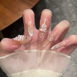 Gros plan détaillé de faux ongles de Noël faits main avec flocons blancs et perles