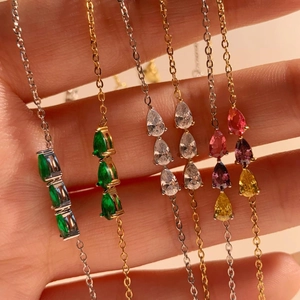 Close-up of gold and silver stainless steel bracelets with colorful zircon gemstones