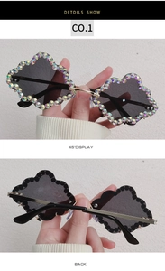 Detail of rimless cloud sunglasses with sparkly rhinestones and gold metal bridge