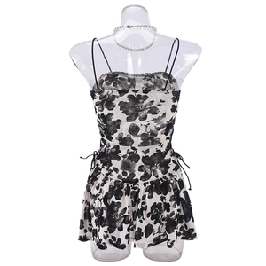 Détail de la robe fleurie avec taille à cordon et ourlet à volants superposés
