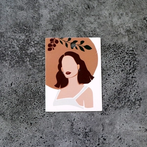Detail of creative jewelry display card featuring a floral female illustration and hanging hole