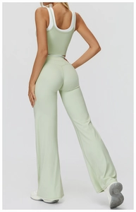 Detail of high-waist flared yoga pants and mint green layered sports top for women