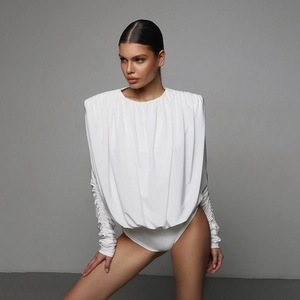 Detail showing white long sleeve bodysuit with pleated texture and padded shoulders