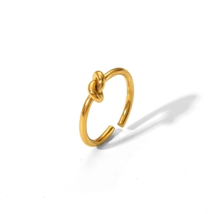 Detail of minimalist gold knotted stainless steel open ring on a white background