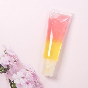 Primer plano de brillo de labios arcoíris de doble capa rosa y amarillo en tubo