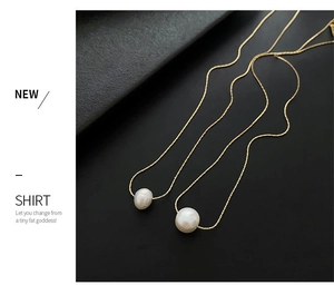 Detail of elegant gold necklaces featuring natural white baroque and round pearls