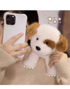 Close-up of fluffy white and brown plush puppy with a green collar held by a model