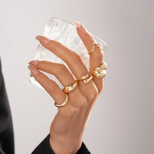 Makro-Detail der glänzenden goldenen Tropfenringe mit Liquid-Metal-Ästhetik