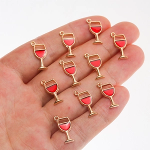 Hand holding red enamel wine glass charms with gold metal frame for DIY jewelry making